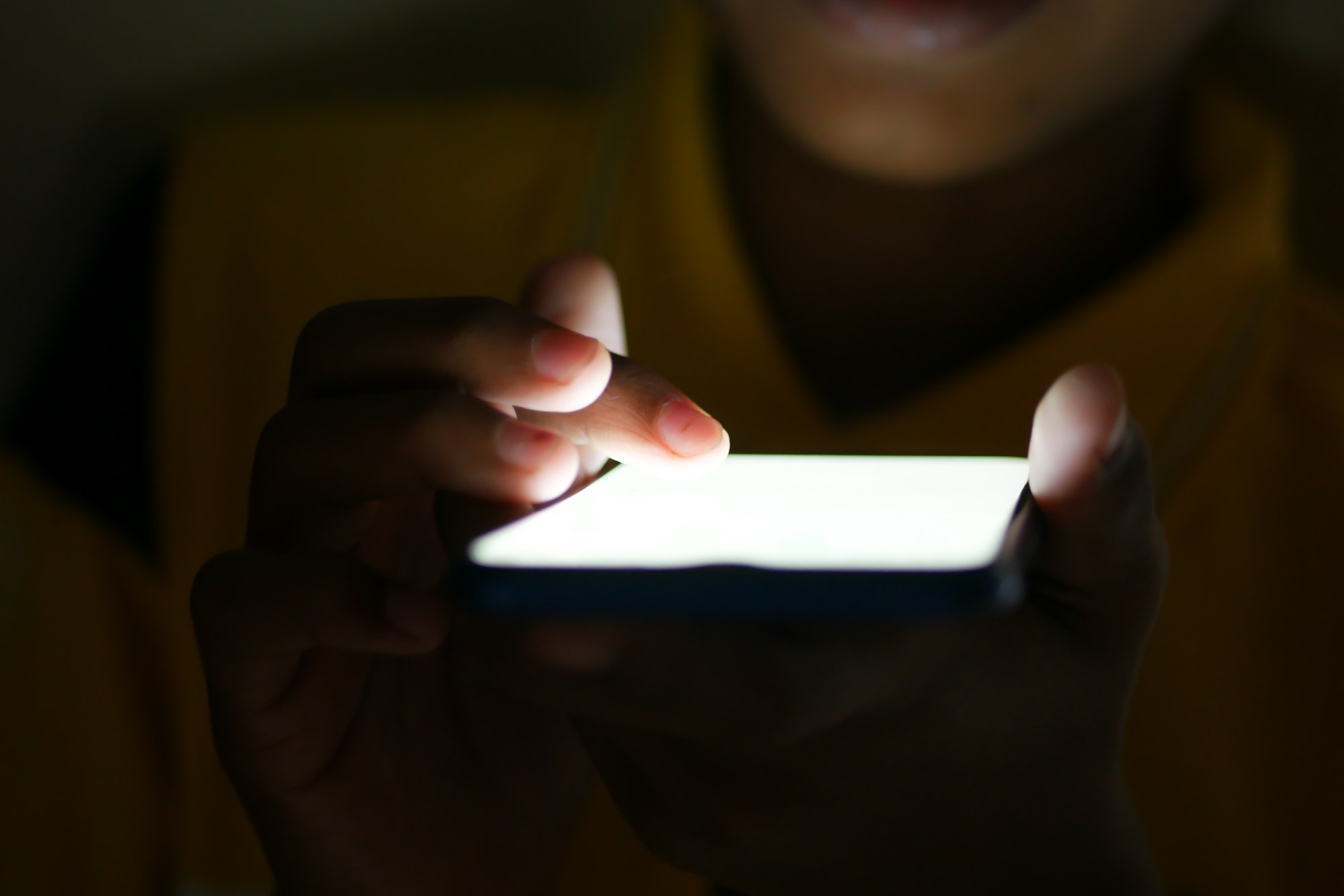 Close up of young man hand using smart phone at night